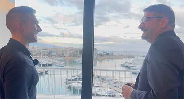 Two people in conversation overlooking a marina
